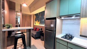 A modern kitchen with a built-in refrigerator, a gas stove, and a dining area with a bar stool.