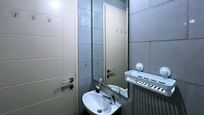 A bathroom with a sink, mirror, and towel rack. - Compact And Best Choice Studio At Anderson Supermall Mansion Apartment (Surabaya)
