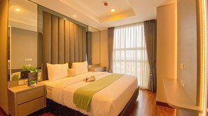 Relax in a spacious room with a large bed, nightstand, and mirror, plus a small table with a plant and a window with a view.