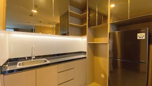 A modern kitchen with a stainless steel refrigerator, a sink, and light-colored cabinets. - Spacious And Homey 2Br Apartment With Private Lift At The Kencana Residence (Jakarta)