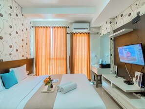 Relax in a stylish room with a large bed, flat-screen TV, and comfortable workspace.