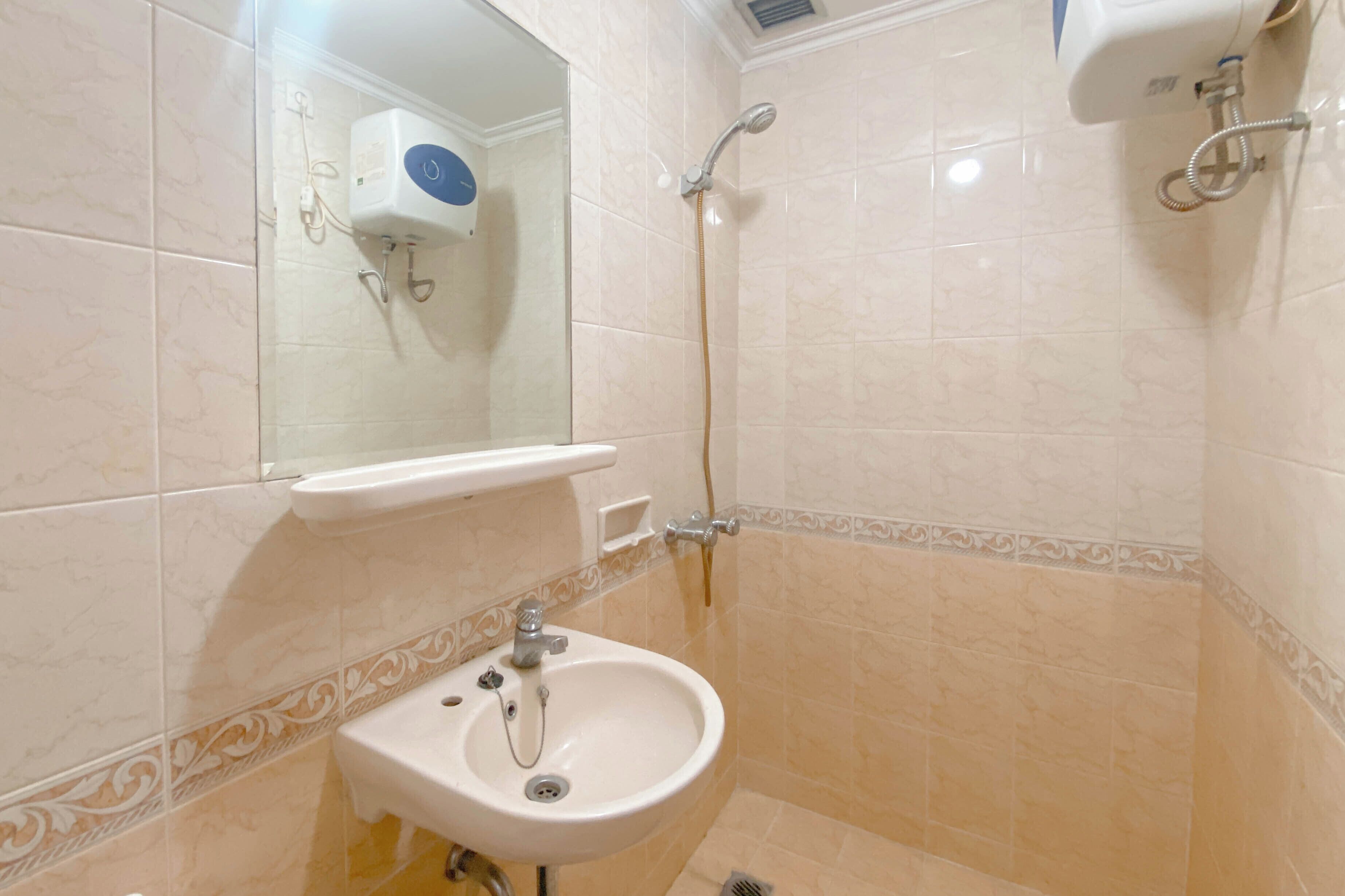 Un bagno con lavandino, specchio e doccia.
