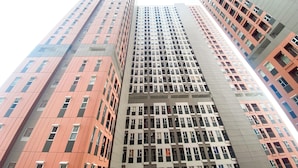 A high-rise building with multiple floors, featuring a mix of architectural styles and window patterns. - Studio At Transpark Juanda Bekasi Timur Apartment (Bekasi)