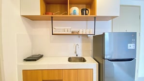 Een moderne keuken met een roestvrijstalen koelkast, een ingebouwd spoelgedeelte en houten keukenkastjes.