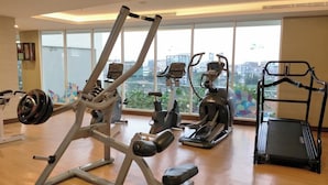 Ein Fitnessstudio mit Cardiogeräten, Krafttrainingsgeräten und Laufband.