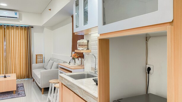 A compact kitchen with a built-in oven, a sink, and a countertop. - Comfort 2Br At Meikarta Apartment Cikarang (Cikarang)