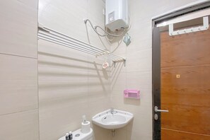 A bathroom with a sink, toilet, and towel rack.