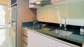A modern kitchen with a stainless steel sink, a gas stove, and white cabinets.