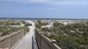 A beach pathway leading to the ocean with beach umbrellas and a wooden boardwalk. - 4203 Newly Renovated 1BR 2BA Direct Ocean/Beach Views Sofa Bed Soaking Tub (Hilton Head Island)