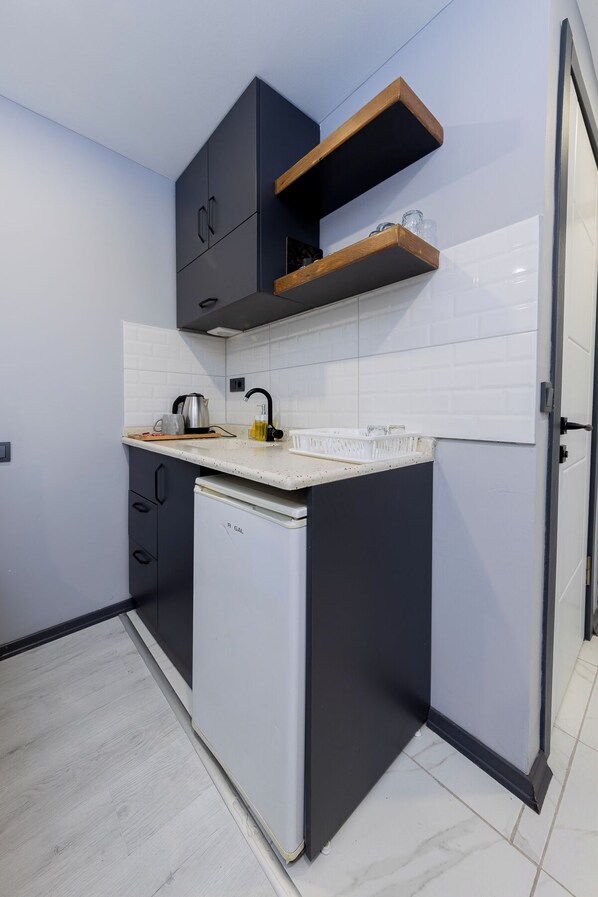 A compact kitchen with a refrigerator, a sink, and a countertop. - AYA LANGA HOTEL (Istanbul)