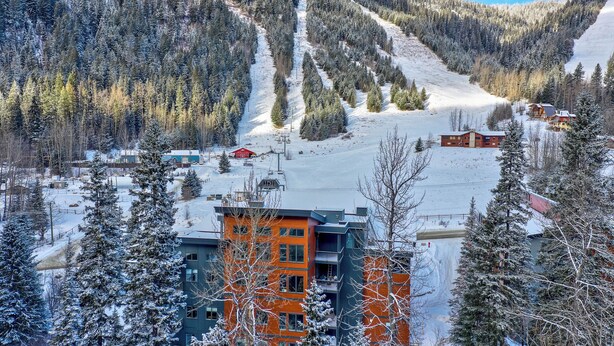 A ski resort with snow-covered slopes, buildings, and a mountain backdrop. - Beautiful & Modern Condo, Ski-In Ski-Out (Sun Peaks)