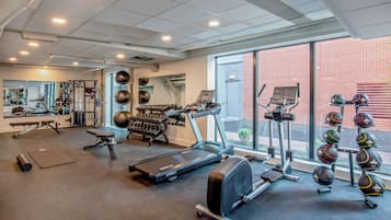 A gym with treadmills, ellipticals, free weights, and exercise balls.
