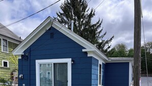 A blue house with a garage, a covered patio, and a fenced yard. - Charming single family Cottage, pet friendly, close to Prov, Woon, MA & highways (Lincoln)