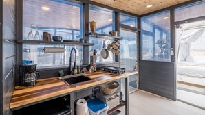 A compact kitchen with wooden countertops, a sink, and various kitchen utensils.