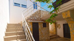 A staircase with a metal railing leading to a stone building with a tiled floor. - Apartment 1362/116992 (Istria - Peroj), 500m from the beach (Peroj)