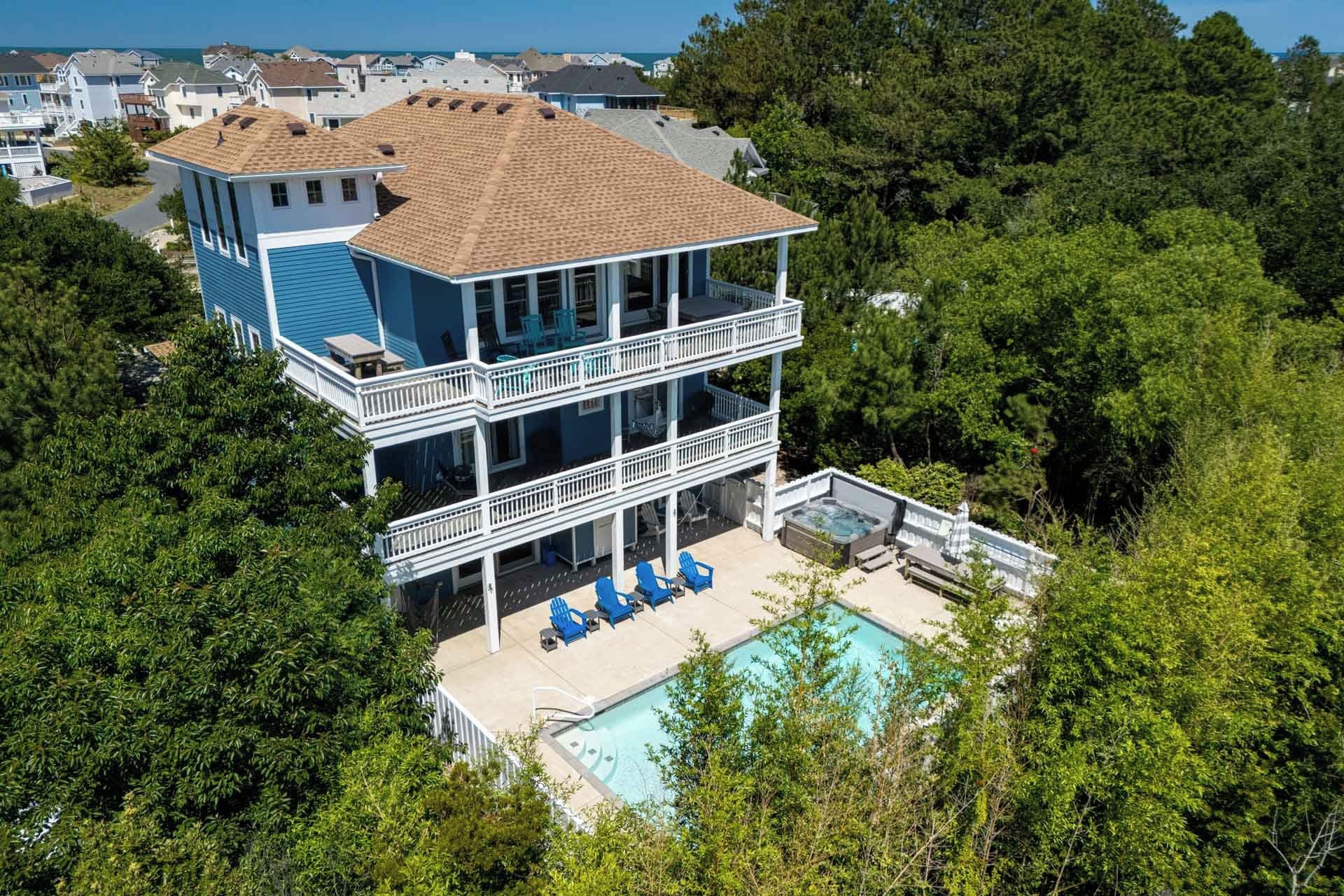A two-story house with a balcony and a swimming pool.