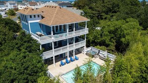 Une maison à deux étages avec un balcon et une piscine.