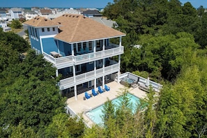 A two-story house with a balcony and a swimming pool.