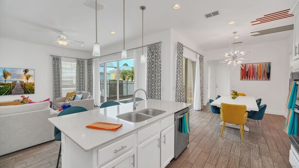 A modern kitchen with a white countertop, stainless steel sink, and a built-in dishwasher. - Charming Retreat at Reunion | 5BR/5BA Villa, Private Pool, Arcade, Themed Kids Rooms & Golf Access (Kissimmee)