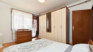 A bedroom with a bed, a dresser, a wardrobe, and a door. - Apartment 2362/116995 (Istria - Rovinj), 800m from the beach (Rovinj)