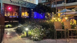 A Seaside Club with outdoor seating, a pathway, and a garden area.