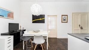 Una cocina moderna con una mesa de comedor, sillas y televisor.