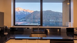 Eine moderne Küche mit großem Fenster mit Blick auf eine gebirgige Landschaft und einen See.