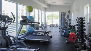 Academia com esteiras, bolas de exercício e equipamentos de musculação.