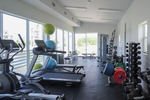 A gym with treadmills, exercise balls, and weightlifting equipment. - Modern 2 bed with pool and gym (West Bay)
