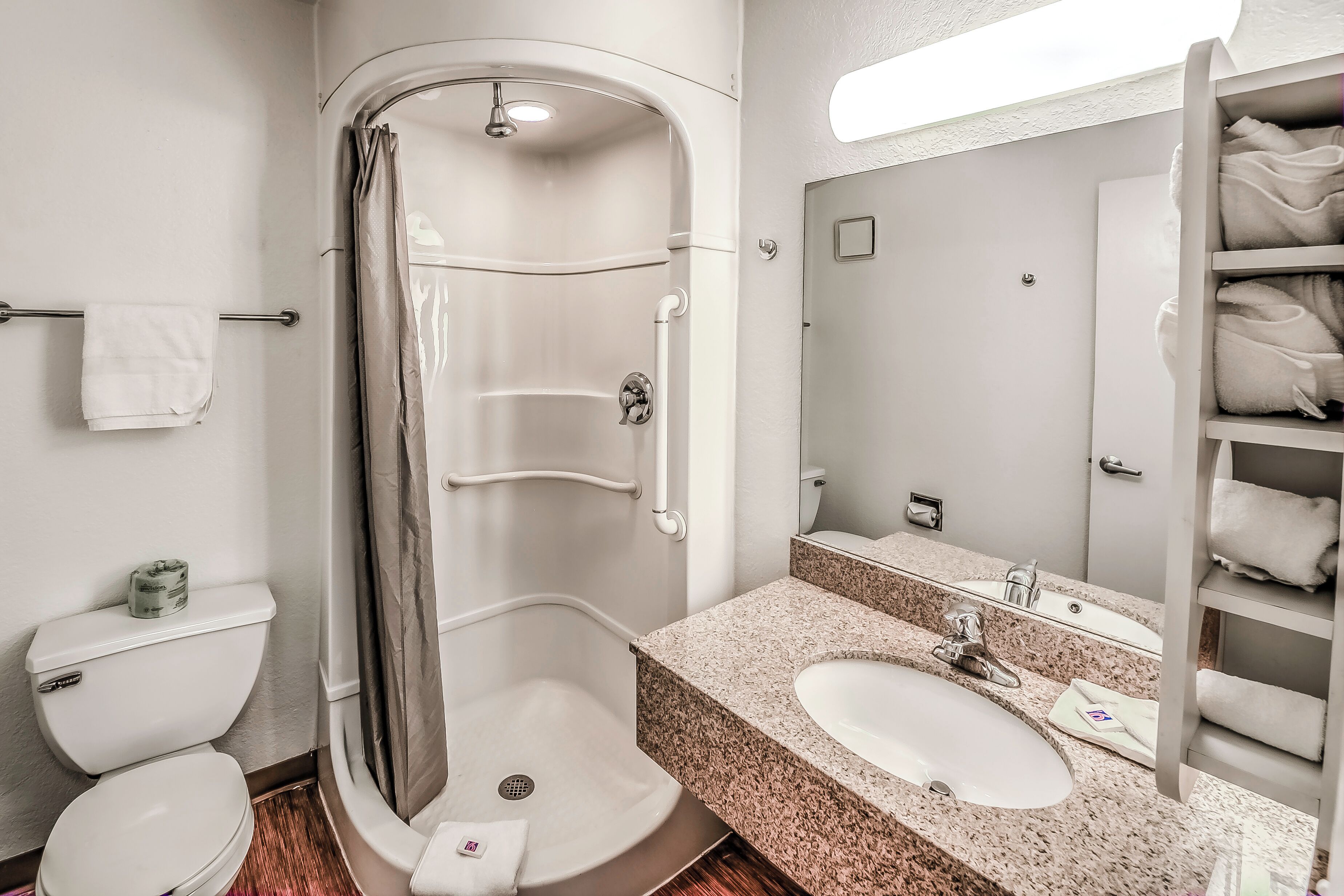 A modern bathroom with a walk-in shower, a toilet, a sink, and a towel rack.