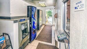 A hotel corridor with an ice machine, a security system notice, and a door leading outside. - Motel 6 – Colorado Springs, CO – South/Metro Area (Colorado Springs)