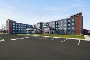 A modern hotel with multiple floors, a parking lot, and a landscaped area in front. - Residence Inn by Marriott Mechanicsburg (Enola)