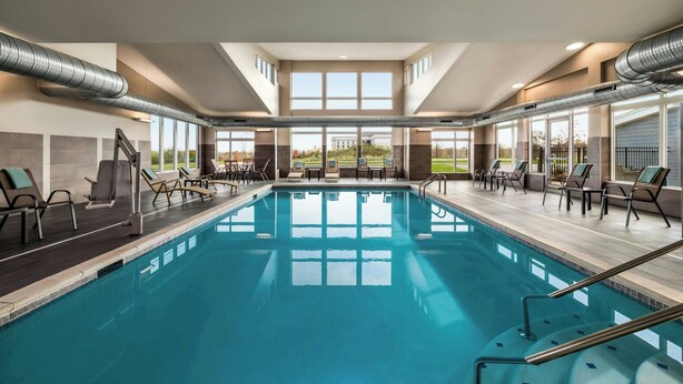 A swimming pool with lounge chairs and a view of the outdoors. - Residence Inn by Marriott Mechanicsburg (Enola)