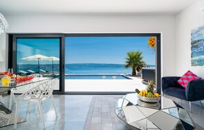 Enjoy a scenic sea view from the outdoor area with a pool and lounge chairs.