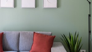 A living room with a grey sofa, red cushions, and a green plant. - Rooftop View Bilo - Bocconi Area (Milano)