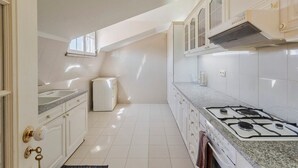 A modern kitchen with white cabinetry, a gas stove, and a built-in oven. - Setúbal Downtown Nº97B (Setúbal)