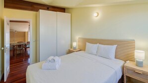 A hotel room with a bed, bedside lamps, a wooden headboard, and a wardrobe. - Setúbal Downtown Nº97B (Setúbal)