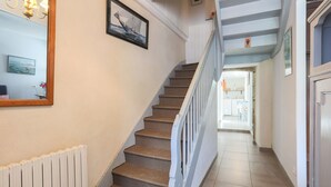 A staircase with a white railing, a framed picture on the wall, and a radiator on the left.