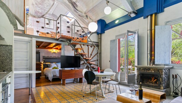 A spacious living area with a fireplace, a staircase, and a television.