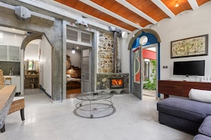 A modern living room with a fireplace, a television, and a dining area with a table and chairs.