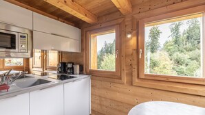 A wooden cabin-style kitchen with a microwave, sink, and coffee maker. - Chalet 'Petit Cosy' with Mountain View, Wi-Fi and Air Conditioning (Combloux)
