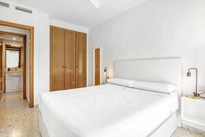 Une chambre à coucher avec un grand lit, une armoire en bois et une table de chevet avec une lampe.