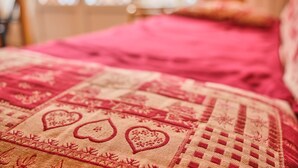 A close-up of a bed with a patterned bedspread. - Chez M & M Apartment – Balcony & Private Parking in Résidence Shrischss (Les Deux-Alpes)