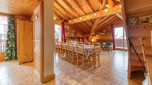 A wooden interior with a dining area, wooden beams, and a fireplace. - Apartment 'Le Pelvoux' with Balcony (Les Deux-Alpes)