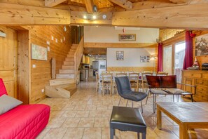 A wooden interior with a staircase, dining area, and kitchen.