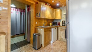 A wooden interior with a kitchen area including a sink, microwave, and refrigerator. - Apartment 'Le Pelvoux' with Balcony (Les Deux-Alpes)