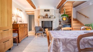 A cozy room with a fireplace, wooden furniture, and a staircase. - Cottage for Four in Nature – Préalpes d'Azur Regional Natural Park (Valderoure)
