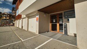 A building with a sign reading 'ACCUEIL RÉSIDENCE' and a parking area with marked spaces.