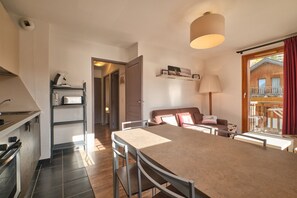 Una cucina moderna con zona pranzo, divano e vista su un edificio in legno.