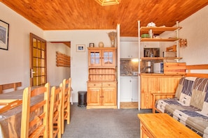 Un intérieur en bois comprenant un coin repas, un canapé et une cuisine.